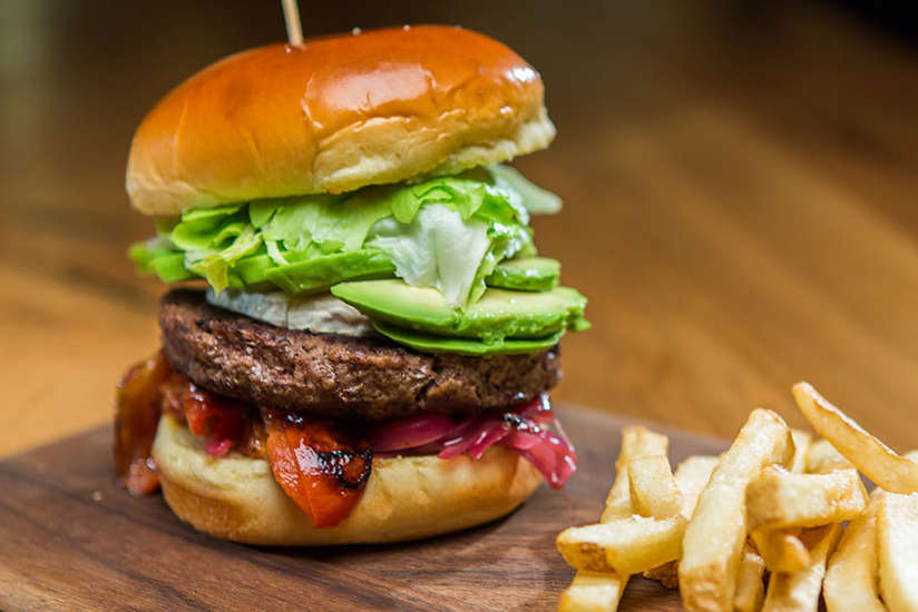 a burger and fries on a wooden board