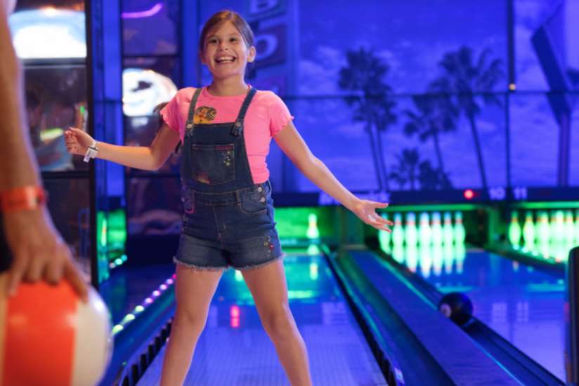 Girl excited to play bowling.