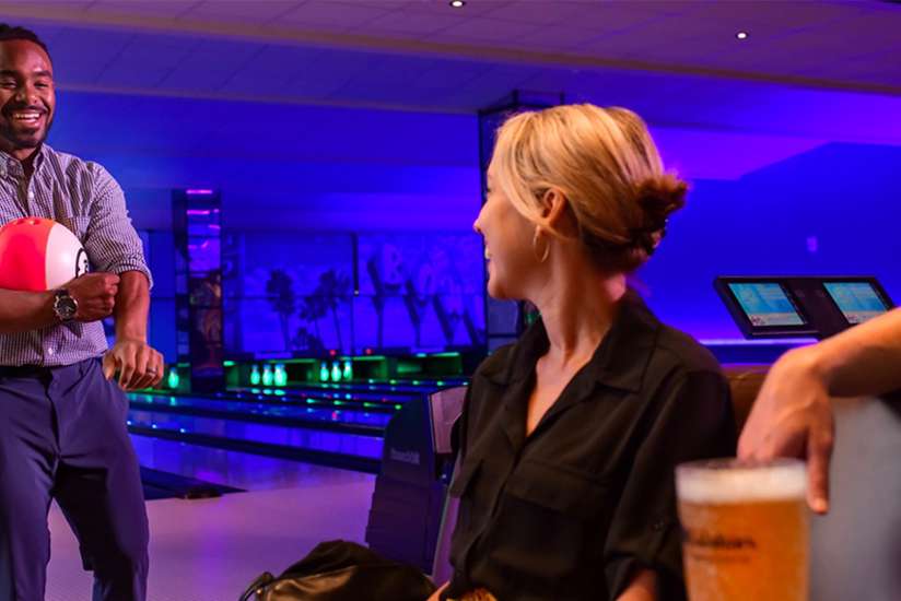 Three people conversing at BLux Bowling.